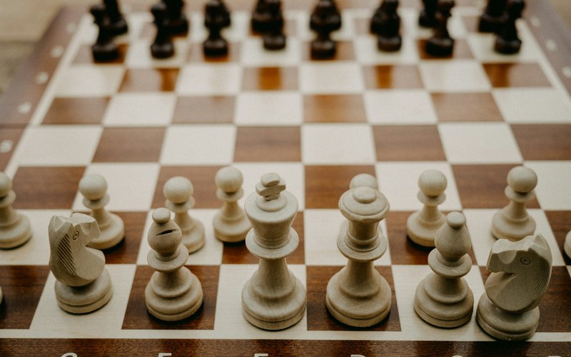 A wooden chess board mid game, representing choosing the right piece for the moment.