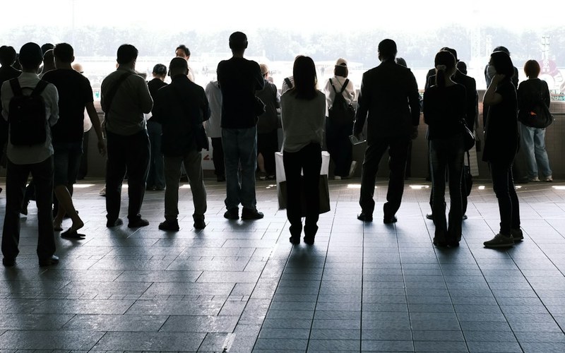 Silhouetted crowd of people waiting, illustrating high applicant volume when hiring Elixir engineers
