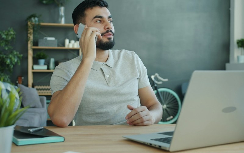 Founder on a phone call at his desk, getting back in touch with a candidate